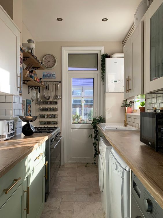 a modern farmhouse mint green galley kitchen with butcherblock countertops, a white subway tile backsplash and a clock
