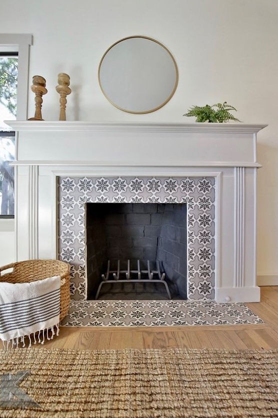 a non-working fireplace with grey star-patterned tiles around and on the floor and a refined white frame and mantel