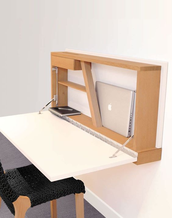 a stylish modern Murphy desk with a white desktop and a plywood base on the wall features soem storage space for holding your laptop