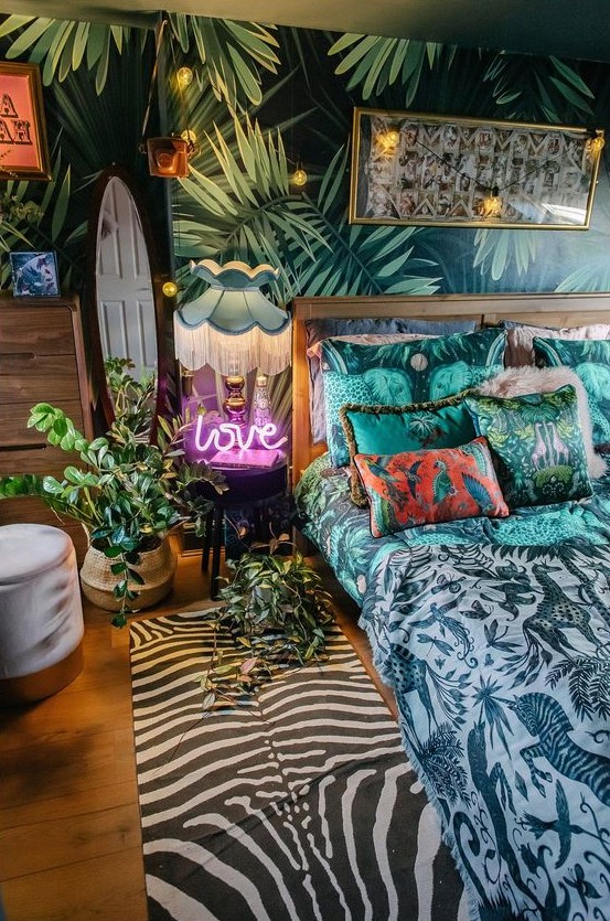a tropical maximalist bedroom with an accent wall, a gilded bed, a mirror and a neon light plus string lights and bold printed textiles here and there
