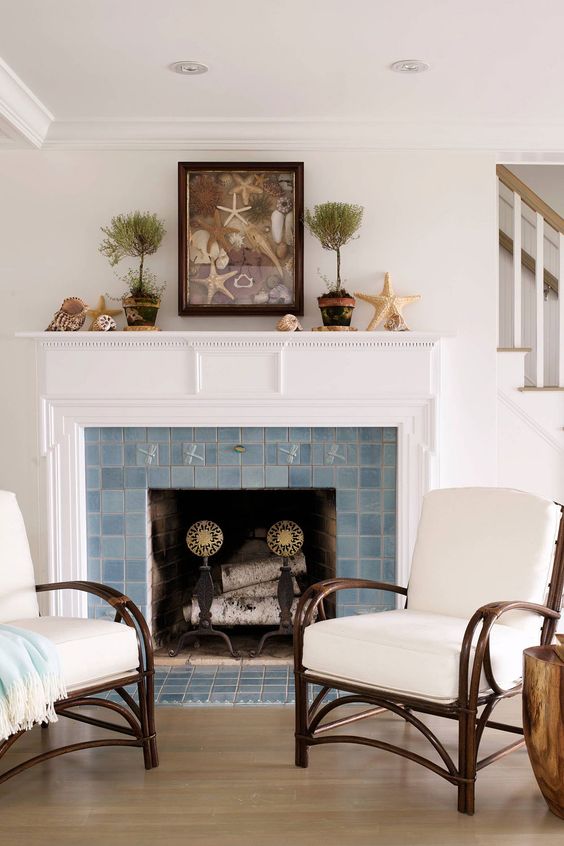 a vintage fireplace with a blue Zellige tile surround and a white mantel is a stylish and chic coastal space idea