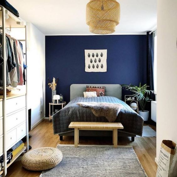 an eclectic bedroom with an upholstered bed, a wicker lampshades, jute and wicker items and a contemporary closet