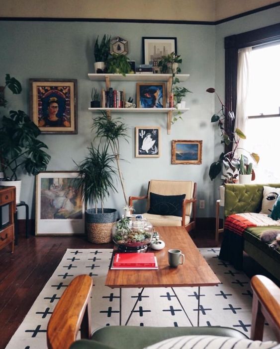 an-eclectic-living-room-with-a-gallery-wall-open-shelves-light-blue-walls-vintage-furniture-and-potted-greenery.jpg