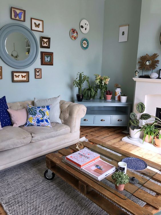 an eclectic space with a pallet coffee table, a neutral sofa unified with light blues and aqua shades