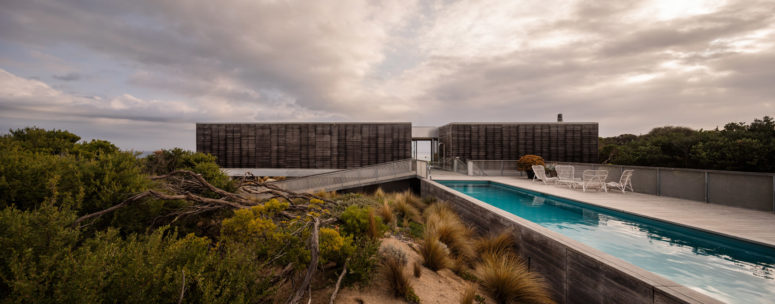 villa with a narrow pool The outdoor space features a long and narrow pool, a minimalist deck and some minimalist metal chairs