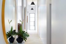 02 a long white Scandinavian hallway with black pendant lamps hanging in a row feels airy and lit up
