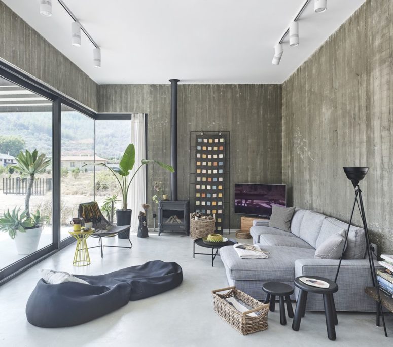 The living room is done with a hearth, a sectional sofa, bean bag chairs, a potted plant and a glazed wall for much light and views The living room is done with a hearth, a sectional sofa, bean bag chairs, a potted plant and a glazed wall for much light and views