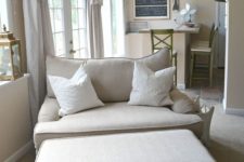 03 a cozy neutral loveseat and a matching ottoman perfectly fit a modern farmhouse living room