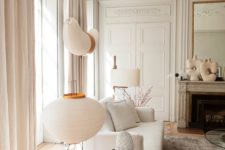 03 an elegant neutral Parisian living room with off-whites, greys and some beige touches is filled with light