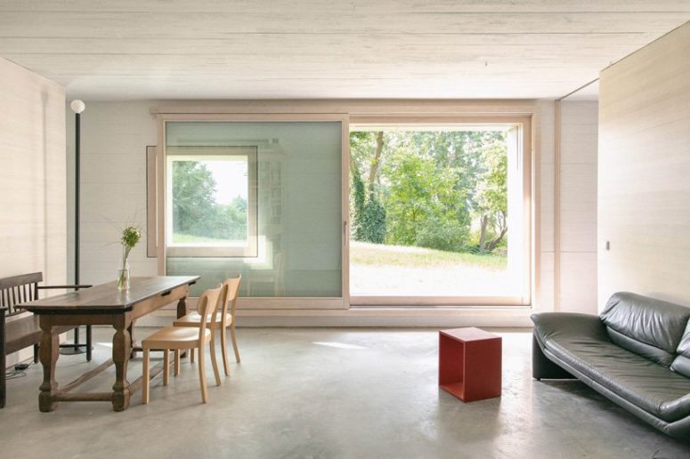 The dining space seamlessly flows into a living room, with just some furniture and glazed walls