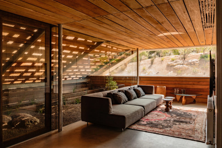 The living room features a real desert inspired orangery right here and some boho and mid century modern furniture plus views The living room features a real desert-inspired orangery right here and some boho and mid-century modern furniture plus views