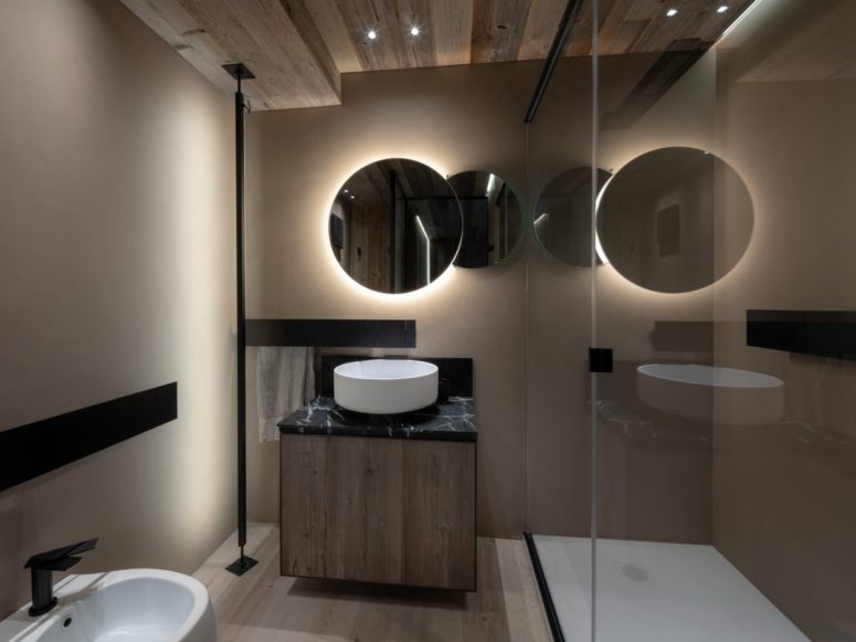 The bathroom also features reclaimed wood, there's a double mirror with lights and minimalist fixtures