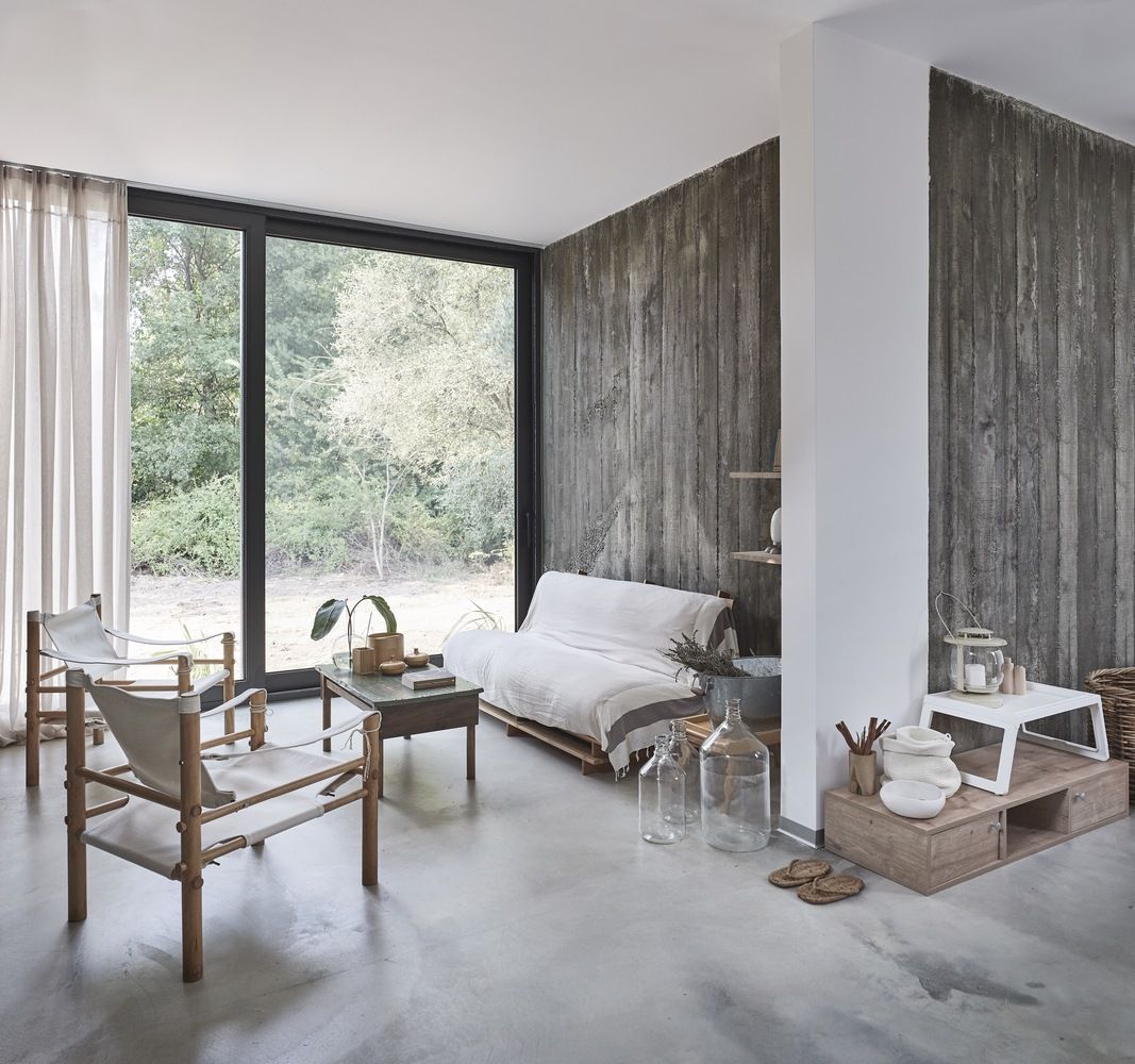Some walls are clad with reclaimed wood, there's rattan furniture and a pallet sofa