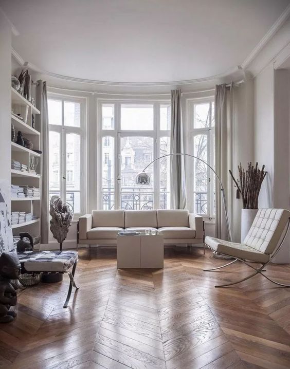 a contemporary Parisian living room with all-whites and a hardwood parquet floor to soften the space