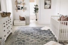 09 a neutral famrhouse meets boho nursery with a beaded chandelier, a Moroccan blanket ottoman and baskets
