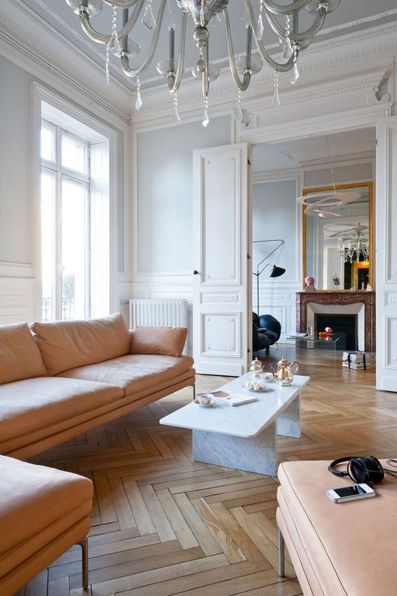pair white walls and hardwood parquet floors adding soft peachy furniture to soothe the space