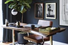 11 navy walls, curtains and pots set the tone of the home office, and a wooden desk and leather chair soften it