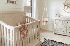 12 a traditional rustic nursery with boho elements like rugs, textiles and a wicker lampshade