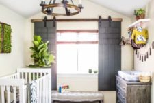 13 a cozy rustic nursery with a tassel garland, printed rugs, a wooden plank ottoman and much greenery