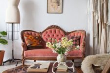 14 a sophisticated coral loveseat with wooden framing and tufted upholstery is a perfect match for this Parisian interior