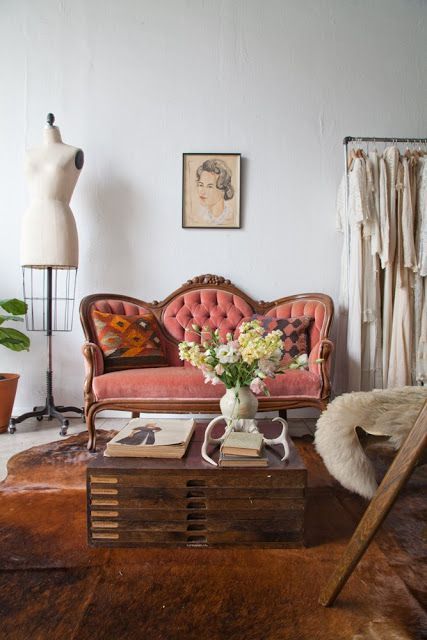 a sophisticated coral loveseat with wooden framing and tufted upholstery is a perfect match for this Parisian interior