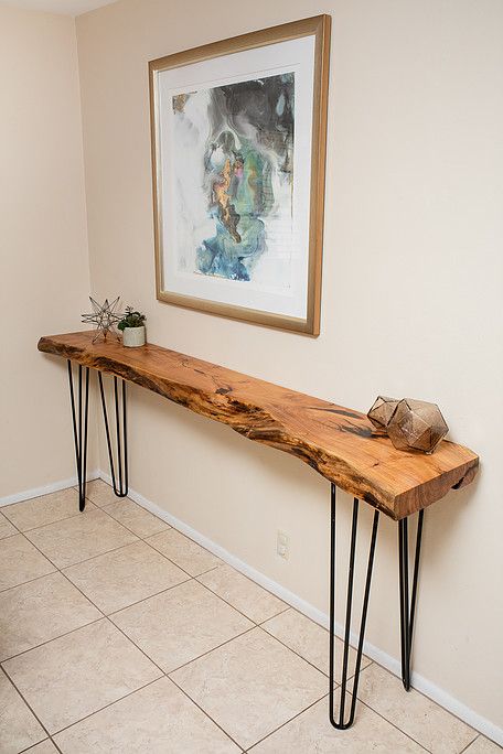 a very sleek and narrow entryway console table with a live edge and hairpin legs is a great way to fill in the space