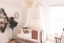 16 a farmhouse meets boho nursery with a statement wicker lamp, a printed rug, jute ottomans and a vintage rocker chairs