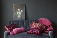 19 a super elegant black velvet loveseat with refined legs and fuchsia and purple pillows for a moody space