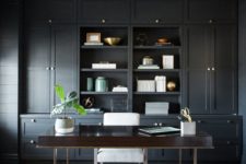 22 a retro-inspired home office in black with an oversized storage unit, a rich stained desk and a star lamp