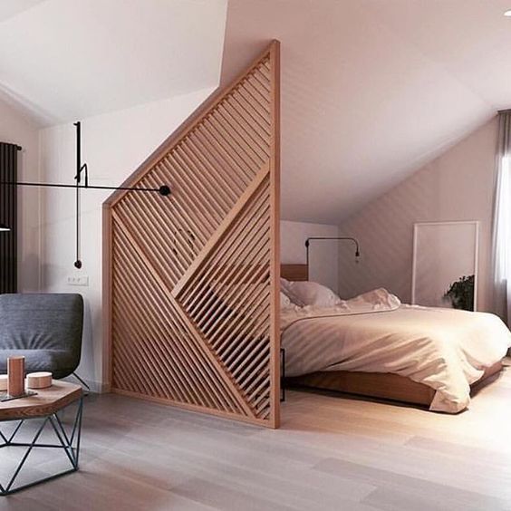 a stylish attic wooden screen with a geometric pattern will subtly divide the spaces