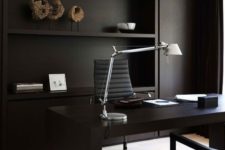 23 a contemporary black home office with built-in shelves and closed storage, a sleek desk and comfortable chair