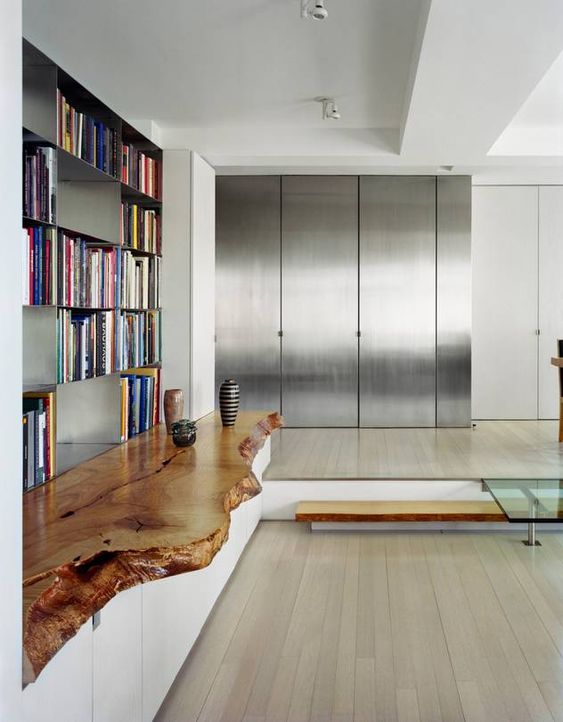 a white credenza with a live edge stained wooden countertop that makes the minimalist space cozy and a bit rustic