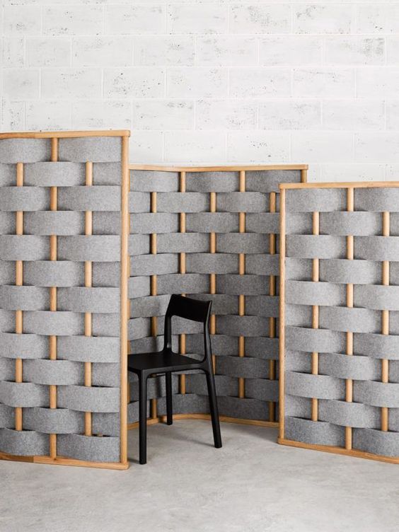 a metal and grey felt room divider will not only separate but also has some acoustic features