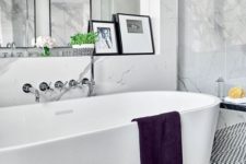 a contemporary Parisian bathroom with an oval tub, artworks, white marble tiles and a geometric floor