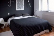a contemporary bedroom with a black accent wall, a white bed and mismatching nightstands and lamps