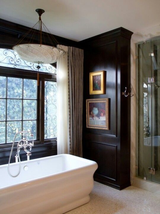 a gorgeous vintage bathroom with black walls, a vintage tub, a gorgeous chandelier and artworks a gorgeous vintage bathroom with black walls, a vintage tub, a gorgeous chandelier and artworks