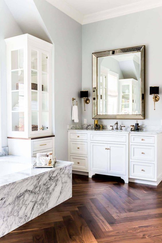 add luxury to the space with stone cladding, a mirror ina metallic frame, elegant lamps and a wood clad floor
