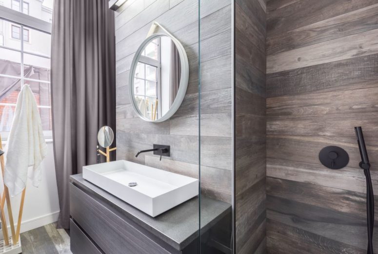 wood imitating tiles, wood grain cabinets and shelves create a very welcoming ambience making the bathroom awesome