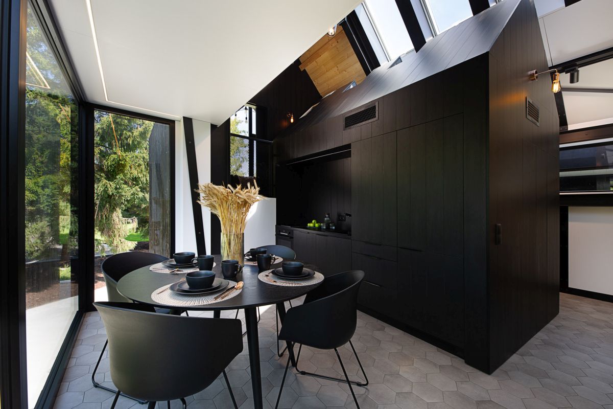 The kitchen is built as a miniature house, all black and with a roof, all the necessary things are hidden within, and the dining zone in black is here