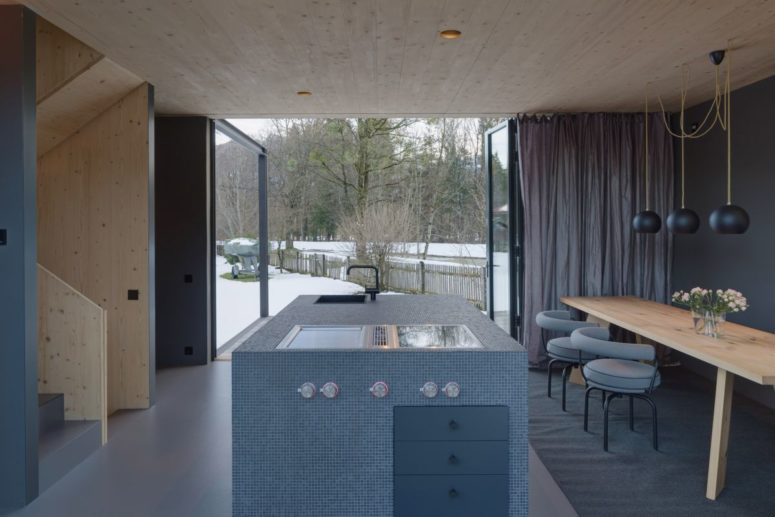 The kitchen island is large, with built in appliances and a glass doors to open the space to outdoors The kitchen island is large, with built-in appliances and a glass doors to open the space to outdoors