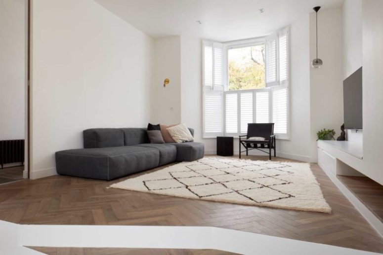 The living room itself is done with a shuttered window, a chic sofa, a printed rug and a TV on the wall The living room itself is done with a shuttered window, a chic sofa, a printed rug and a TV on the wall