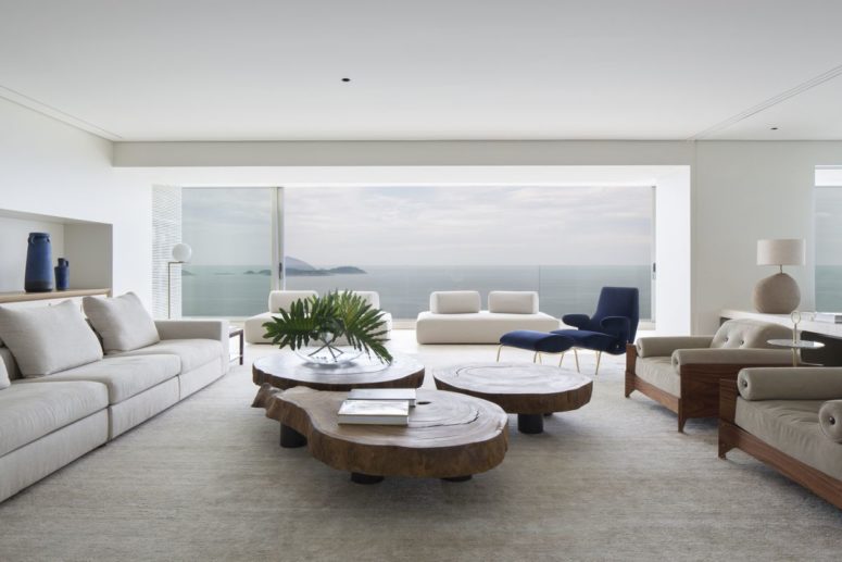 The living room featured three live edge wood tables at the center, surrounded by sofas and armchairs, its a perfect social zone The living room featured three live edge wood tables at the center, surrounded by sofas and armchairs, its a perfect social zone