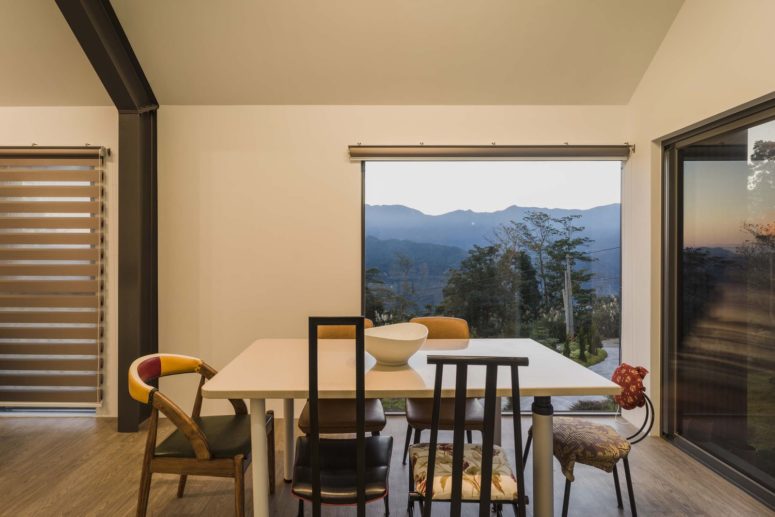 A square shaped dining table with diverse chairs around it creates a very casual and friendly vibe, there's a gorgeous view A square-shaped dining table with diverse chairs around it creates a very casual and friendly vibe, there's a gorgeous view