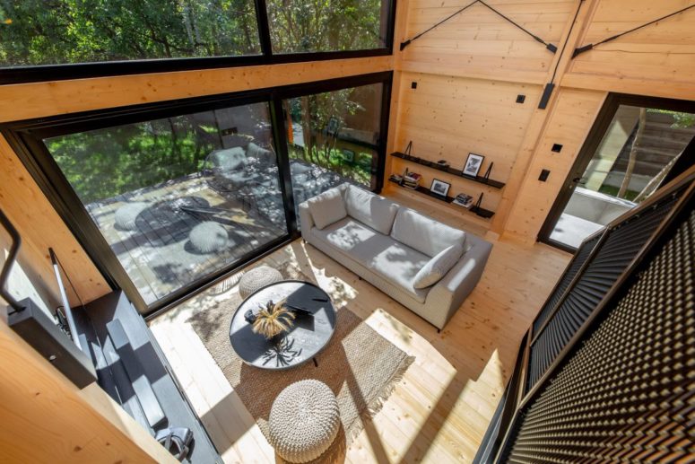 Large sliding doors open the living room towards a deck letting the owners enjoy the views and nature around Large sliding doors open the living room towards a deck letting the owners enjoy the views and nature around