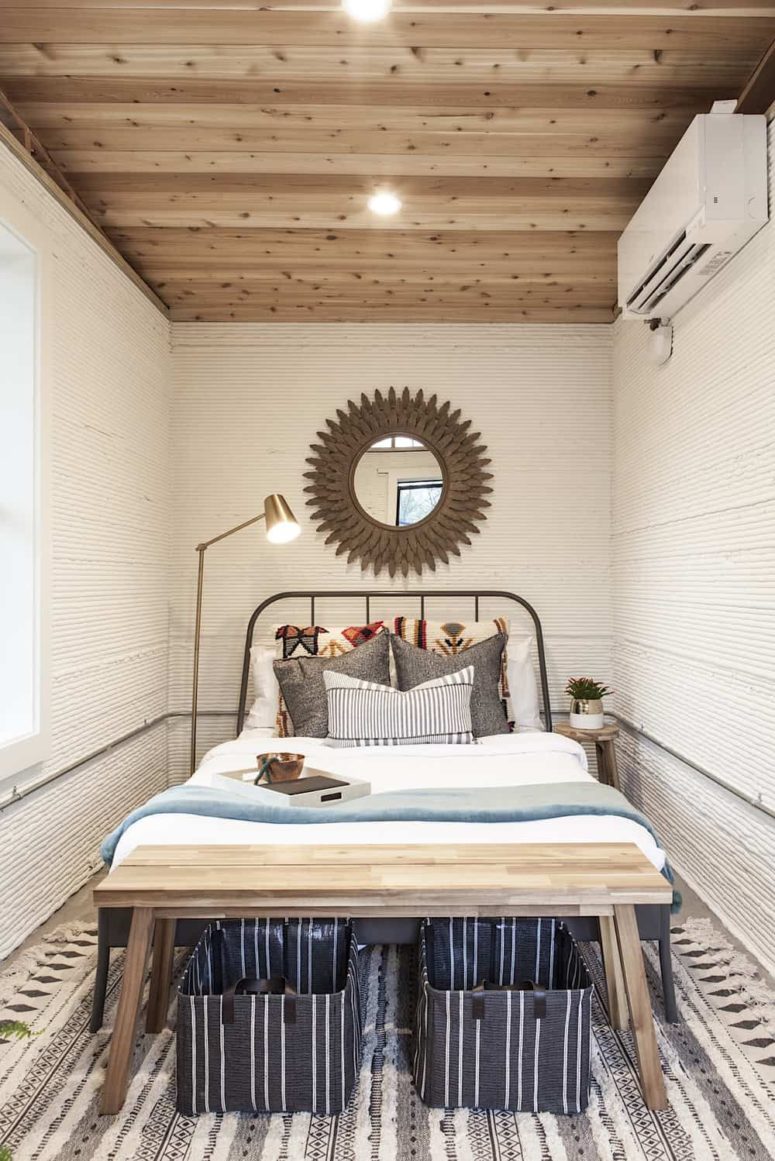 super small yet practical bedroom The bedroom is small yet cozy, with a metal bed, a wooden bench and a statement mirror plus a floor lamp