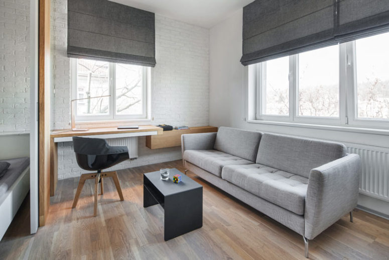 The living room features a home office nook, a comfy sofa with a coffee table and shades and there's a bedroom nok here The living room features a home office nook, a comfy sofa with a coffee table and shades and there's a bedroom nok here