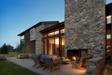 05 There’s an outdoor living room with a fireplace, mid-century modern furniture and lights