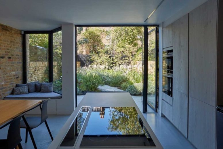 the kitchen can be opened to outdoors with a glass folding door, which leads to the garden