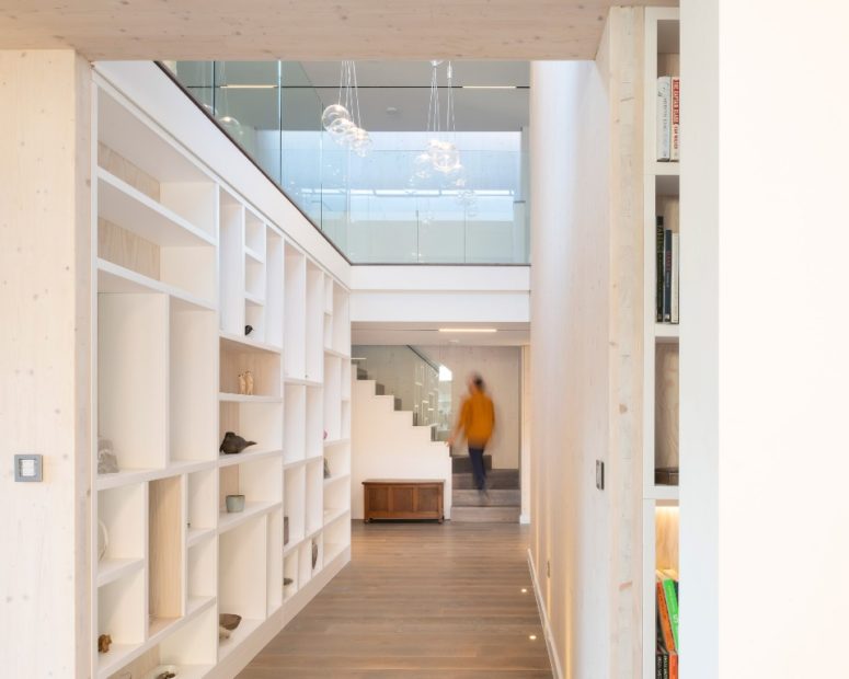 a practical entryway design The entryway is done with cool glass bubble pendant lamps and a large storage unit that doubles as a space divider