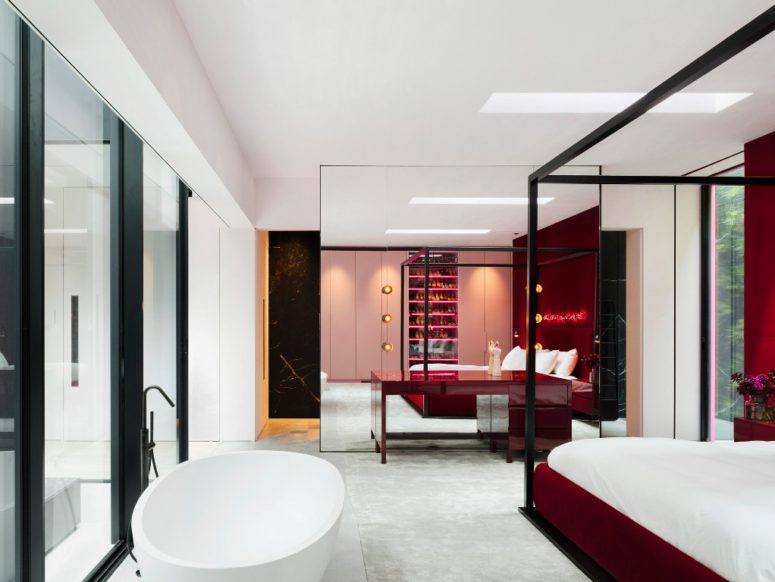 The master bedroom and bathroom is done with deep red touches and an oval tub is placed right next to the bed